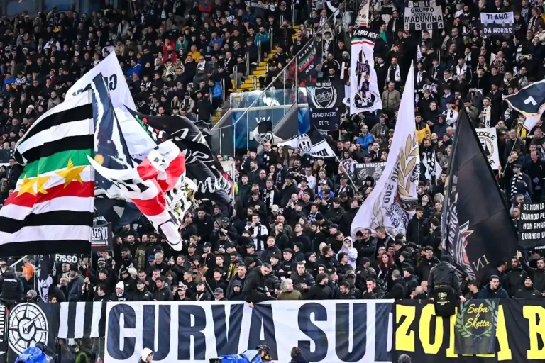 Tifosi della Juventus nella Curva Sud agitano bandiere bianche e nere durante una partita all'Allianz Stadium