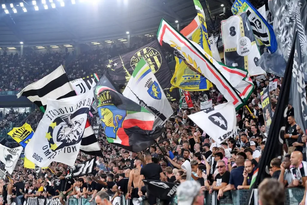 Tifosi della Juventus sventolano bandiere bianconere all'Allianz Stadium durante una partita casalinga