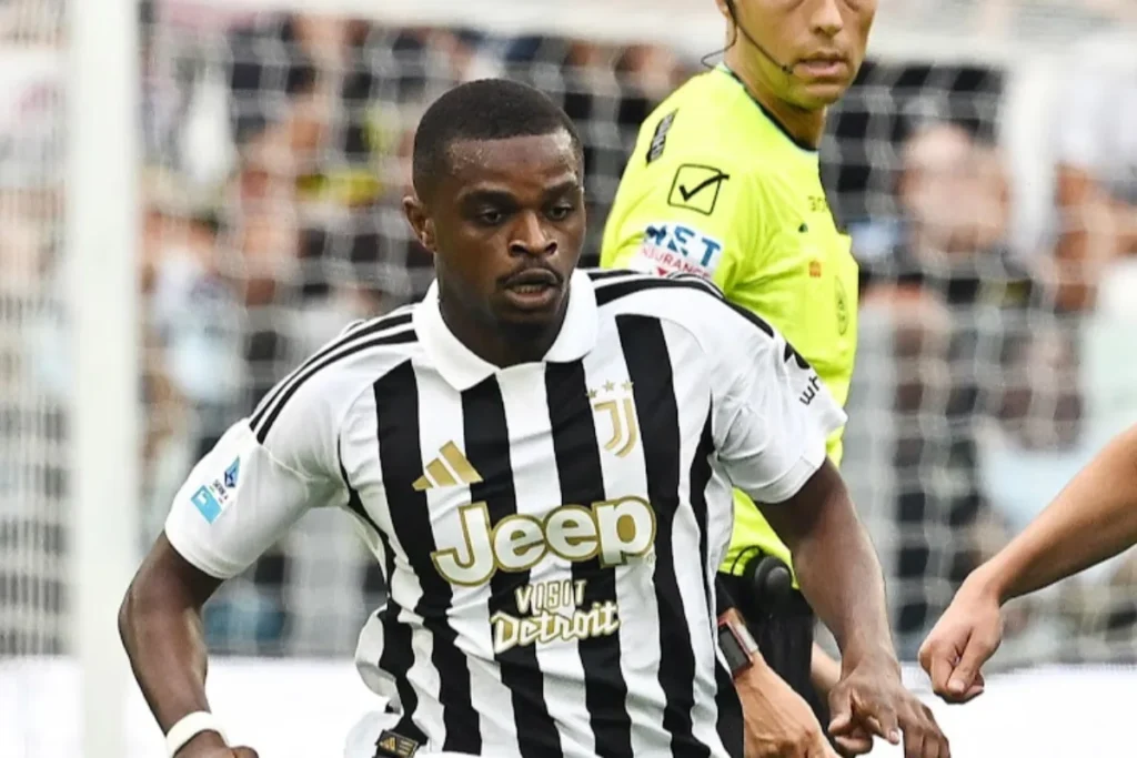 Giocatore della Juventus con maglia bianconera a strisce e sponsor Jeep in azione, arbitro in giallo sullo sfondo