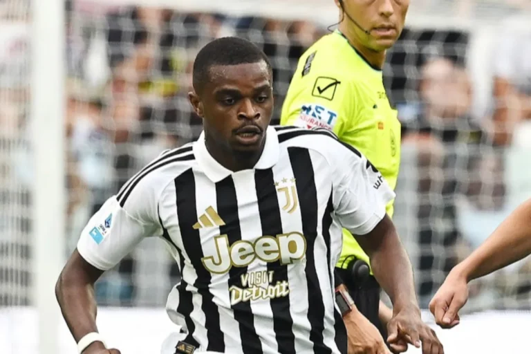 Giocatore della Juventus con maglia bianconera a strisce e sponsor Jeep in azione, arbitro in giallo sullo sfondo