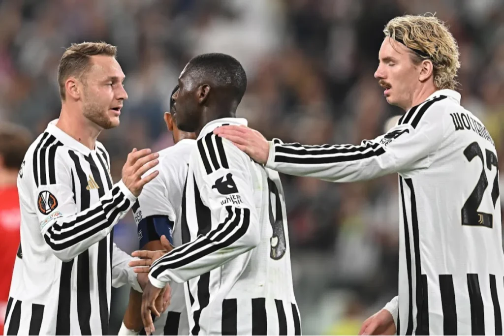Calciatori della Juventus in maglia bianconera si stringono in campo durante una partita