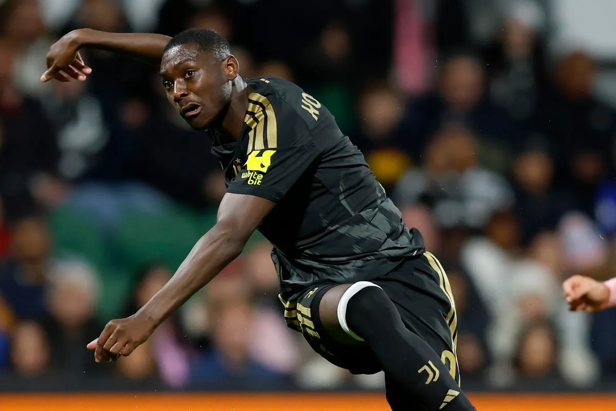 Kolo Muani in maglia nera Juventus con dettagli oro durante un'azione di gioco, con il braccio teso