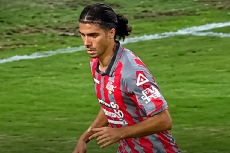 Giocatore della Juventus in maglia a strisce rosso-grigia durante una partita, in corsa sul campo