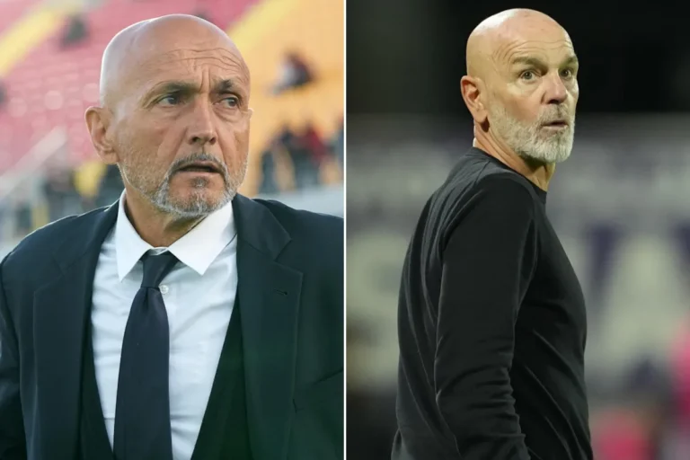 Due uomini calvi in primo piano: a sinistra in abito scuro con cravatta, a destra in maglione nero, con sfondo sfocato da sta
