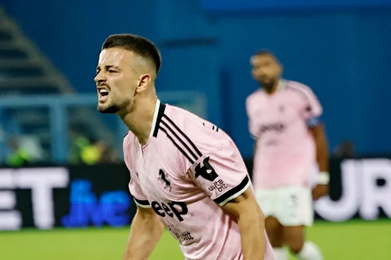 Giocatore della Juventus in maglia rosa esulta durante la partita, con compagni sullo sfondo